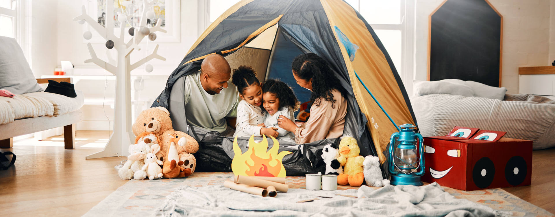 Family camping in their living room with toys around Family camping in their living room with toys around